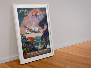 Fly to the Caribbean by Clipper Pan American poster in a white frame leaning against a wall