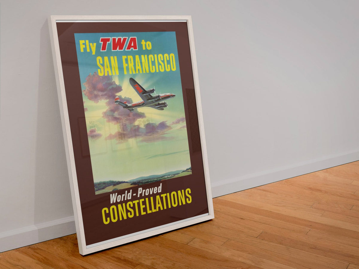 Fly TWA to San Francisco Constellations poster in a white frame leaning against a wall