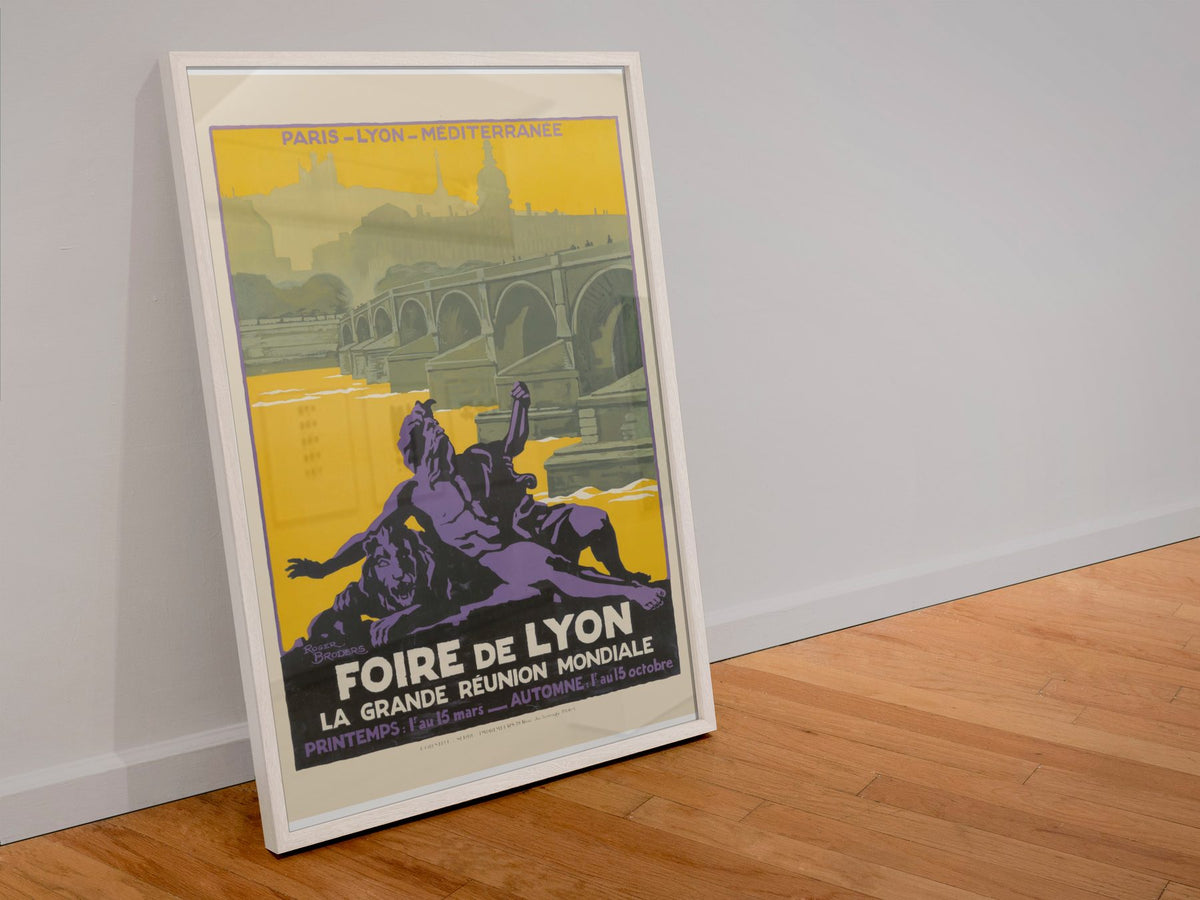 Foire de Lyon poster in a white frame leaning against a wall