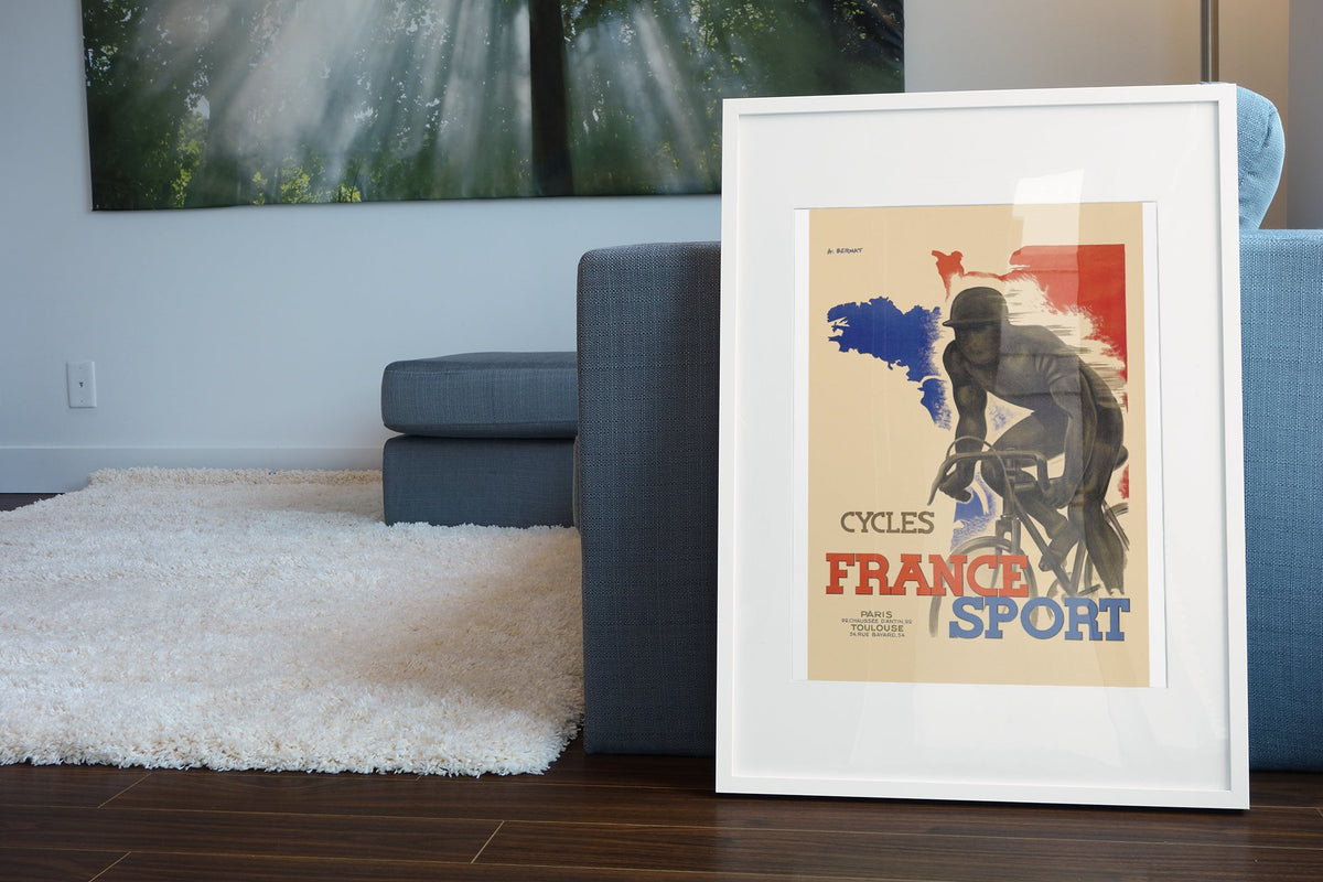 France Sport Cycles poster leaning beside a blue sofa