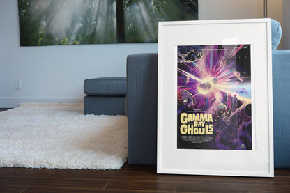 Gamma Ray Ghouls, NASA Galaxy of Horrors poster in a white frame leaning beside a blue sofa