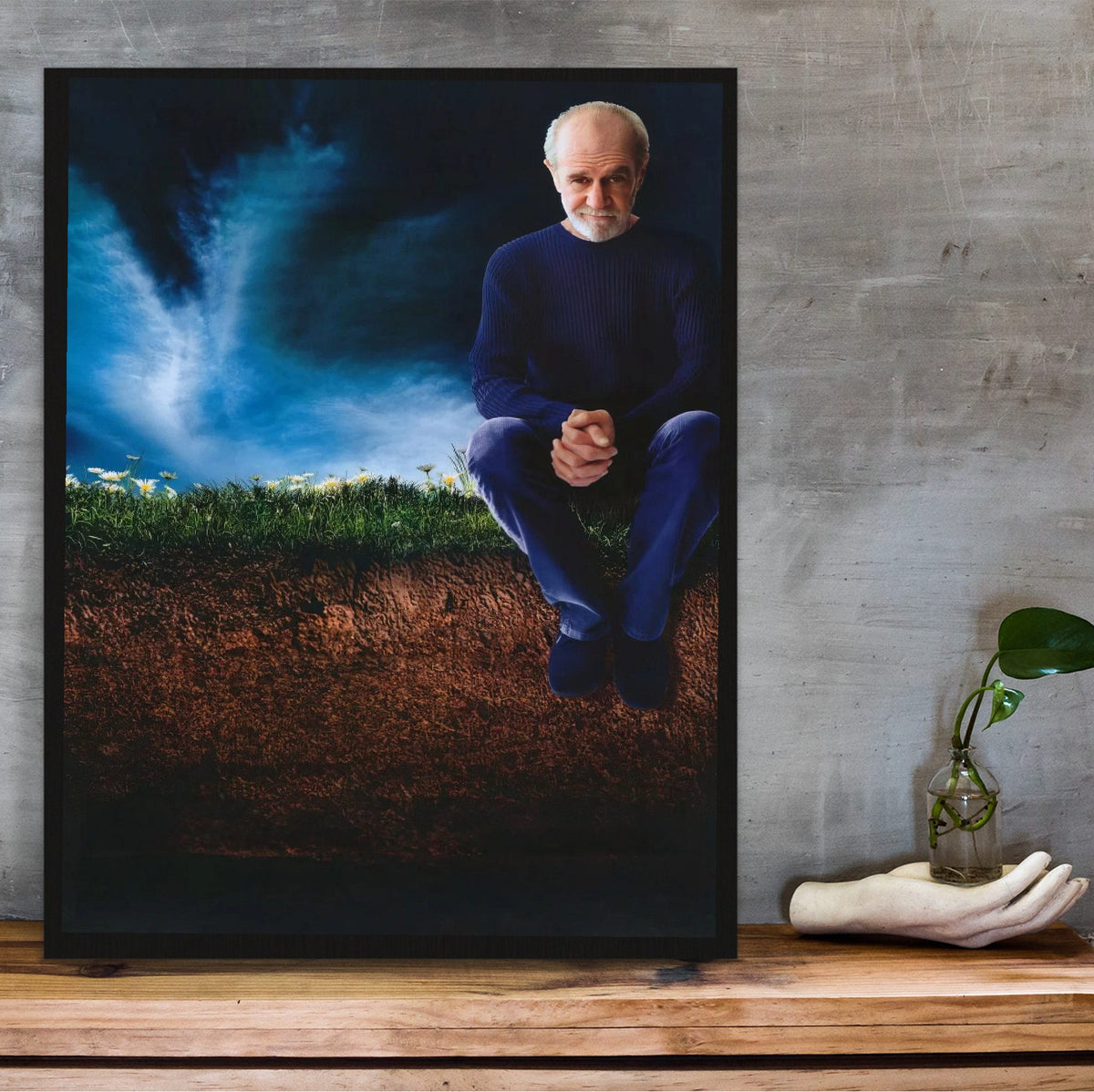 George Carlin: Life Is Worth Losing (2005) Movie Key Art poster in a black frame on a wooden shelf against concrete