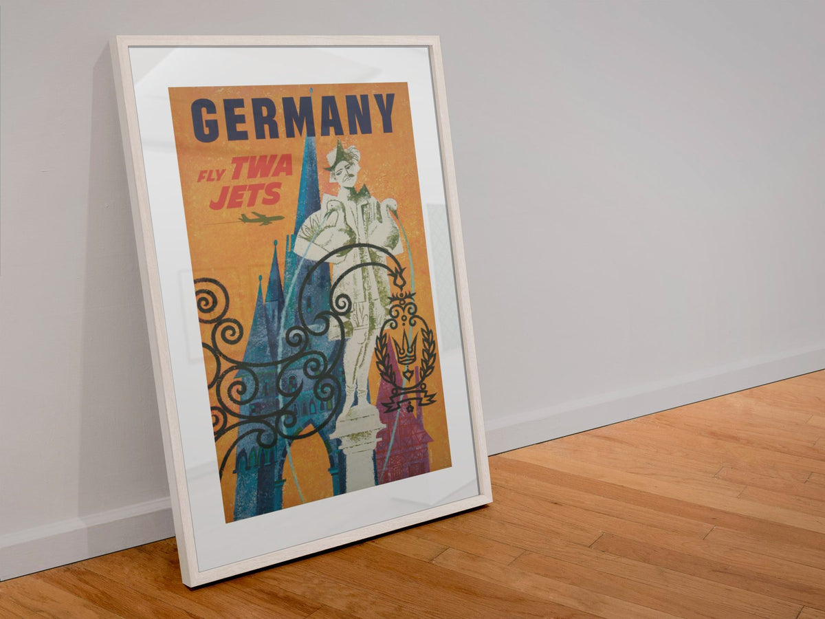 Germany Fly TWA poster in a white frame leaning against a wall
