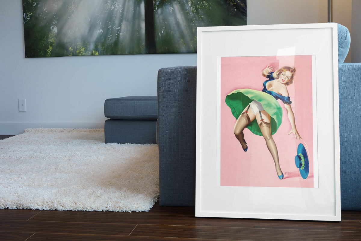 Girl with Dropped Hat poster leaning beside a blue sofa