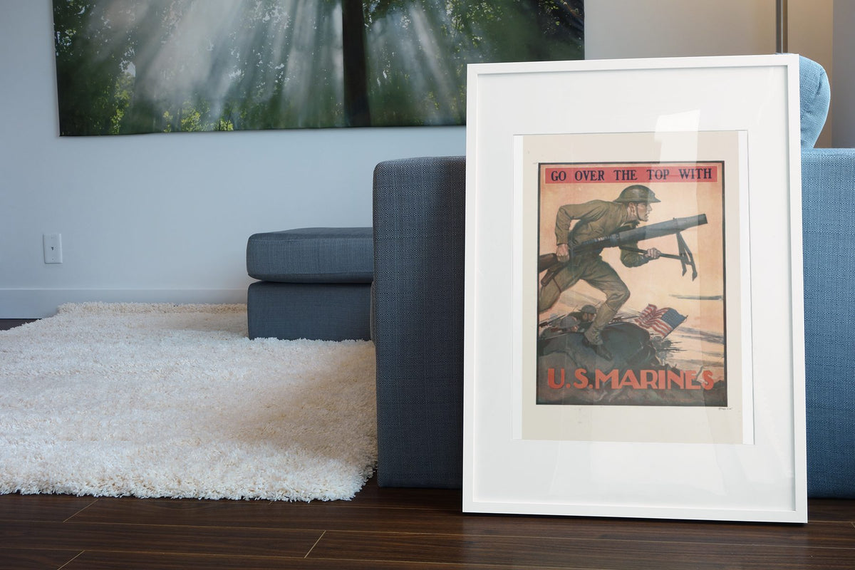 Go Over the Top with U.S. Marines poster leaning beside a blue sofa