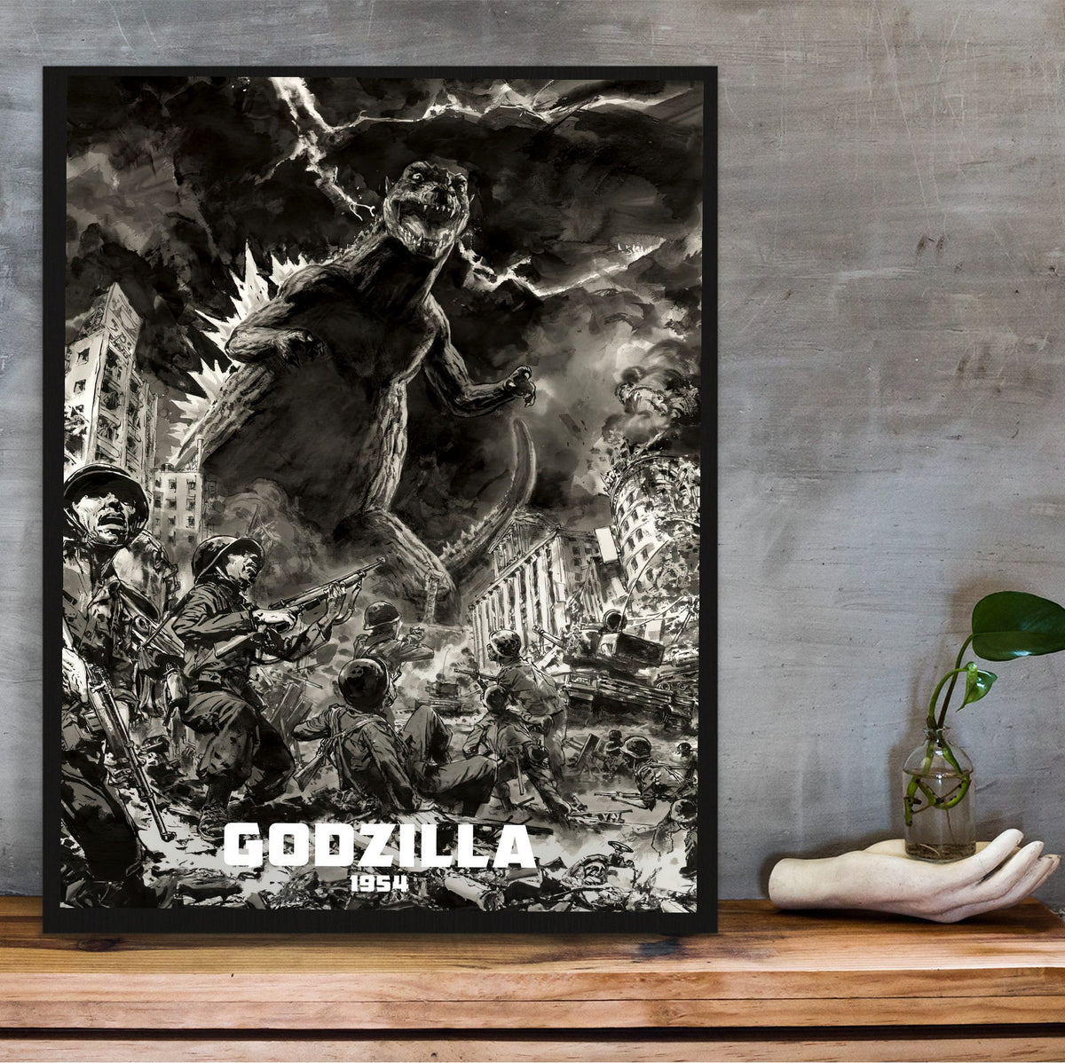 Godzilla (1954) Movie Illustrated Art poster in a black frame on a wooden shelf against concrete