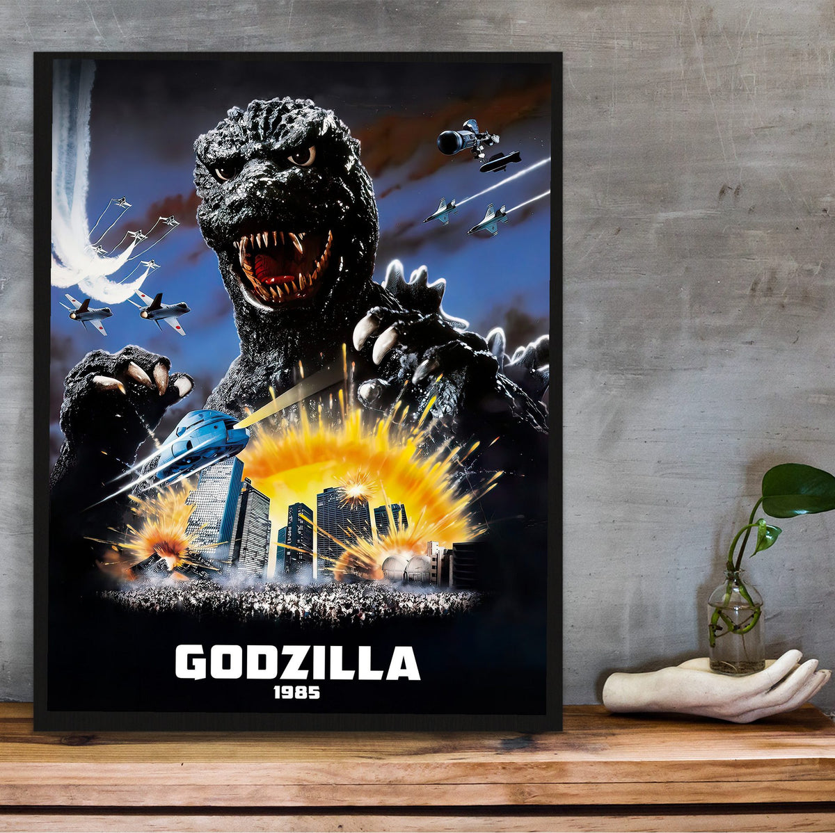 Godzilla 1985 (1985) Movie Key Art poster in a black frame on a wooden shelf against concrete
