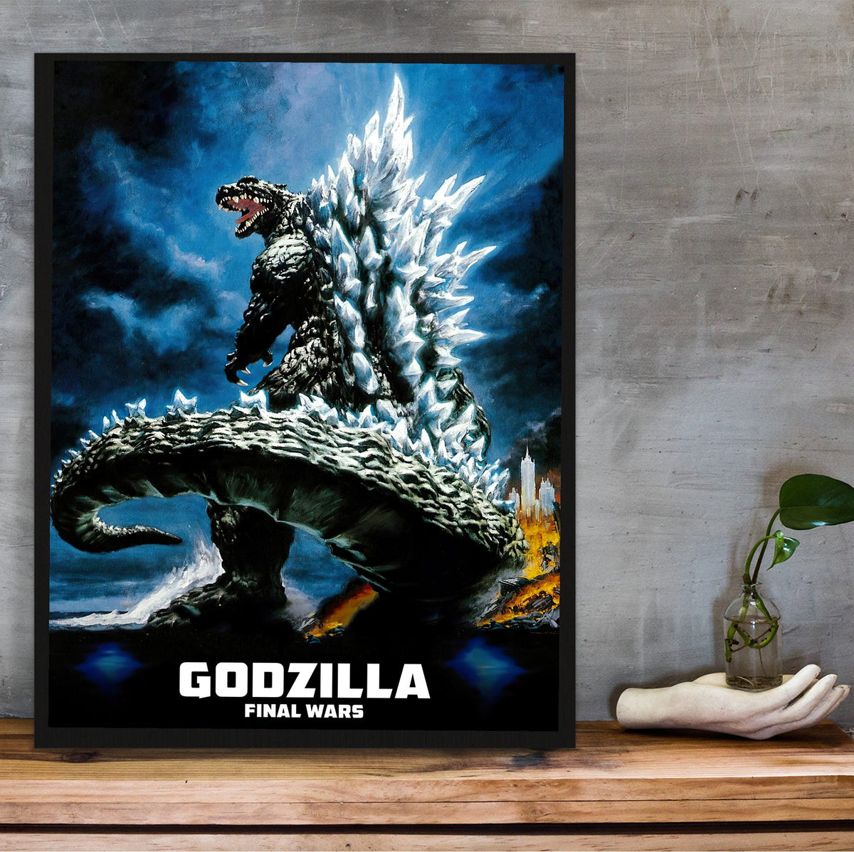 Godzilla: Final Wars (2004) Movie Key Art poster in a black frame on a wooden shelf against concrete