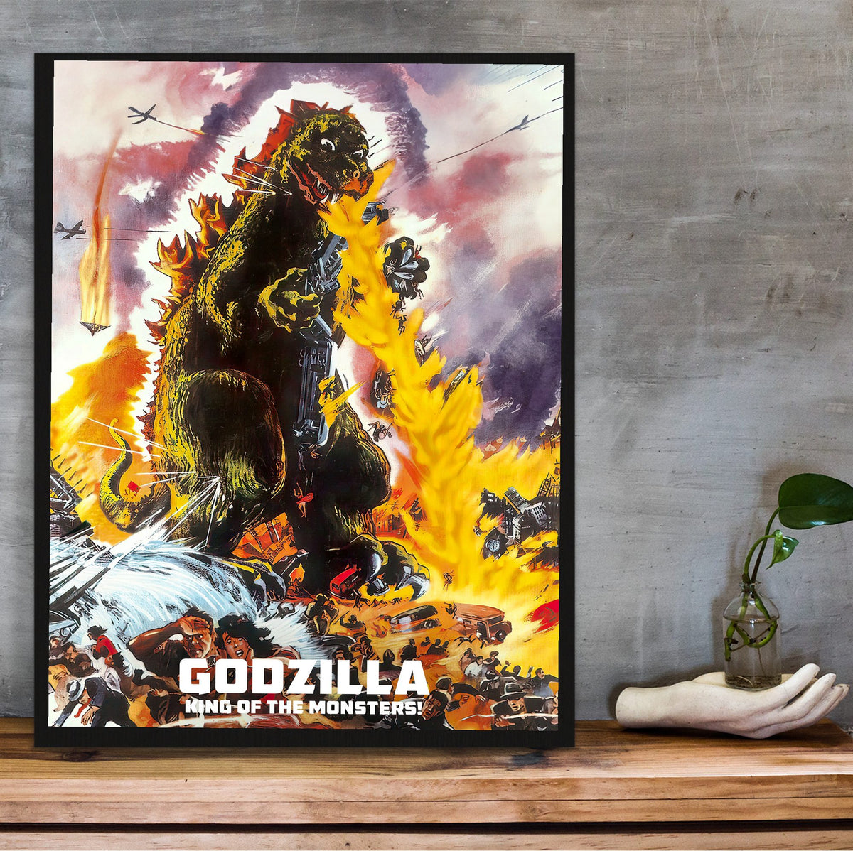 Godzilla, King of the Monsters! (1956) Movie Illustrated Art poster in a black frame on a wooden shelf against concrete