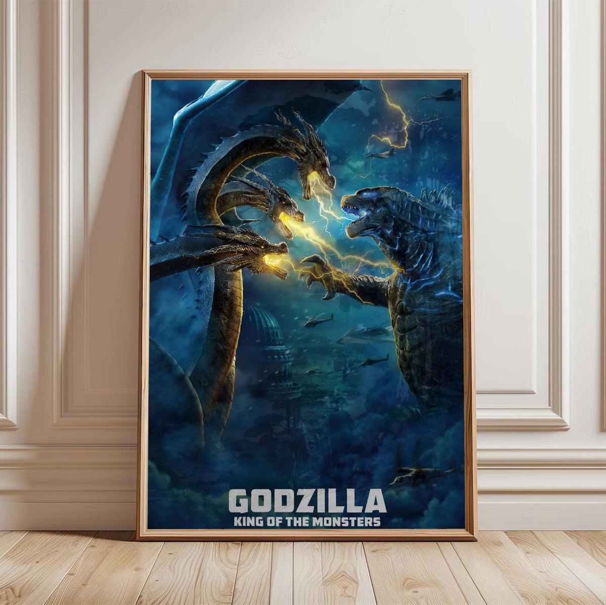 Godzilla: King of the Monsters (2019) Movie Ghidorah Battle Art poster in a light oak frame leaning against a white wall