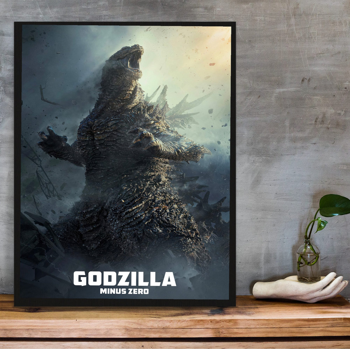 Godzilla Minus Zero (2026) Movie Key Art poster in a black frame on a wooden shelf against concrete