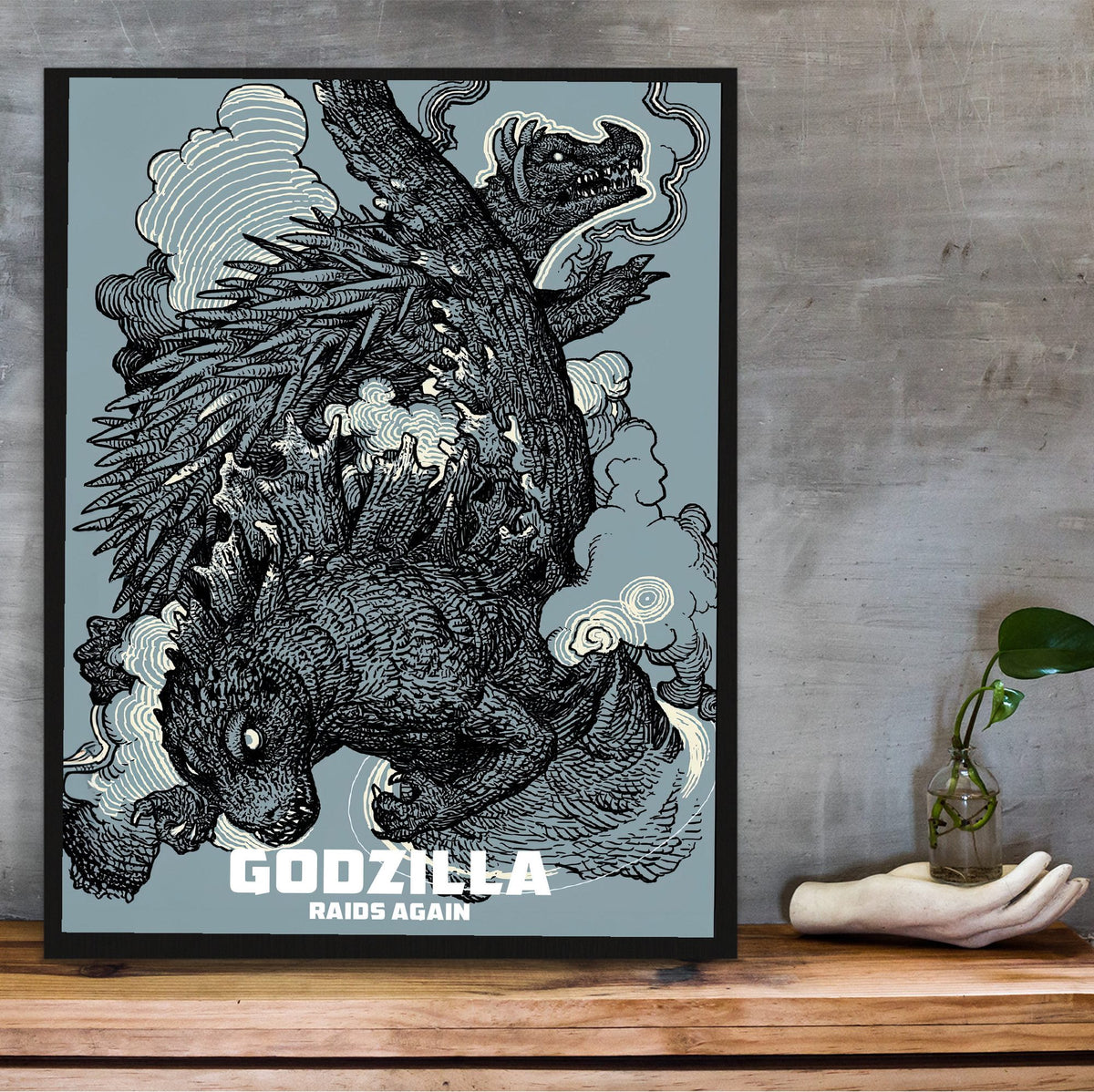 Godzilla Raids Again (1955) Movie Ink Illustration Art poster in a black frame on a wooden shelf against concrete