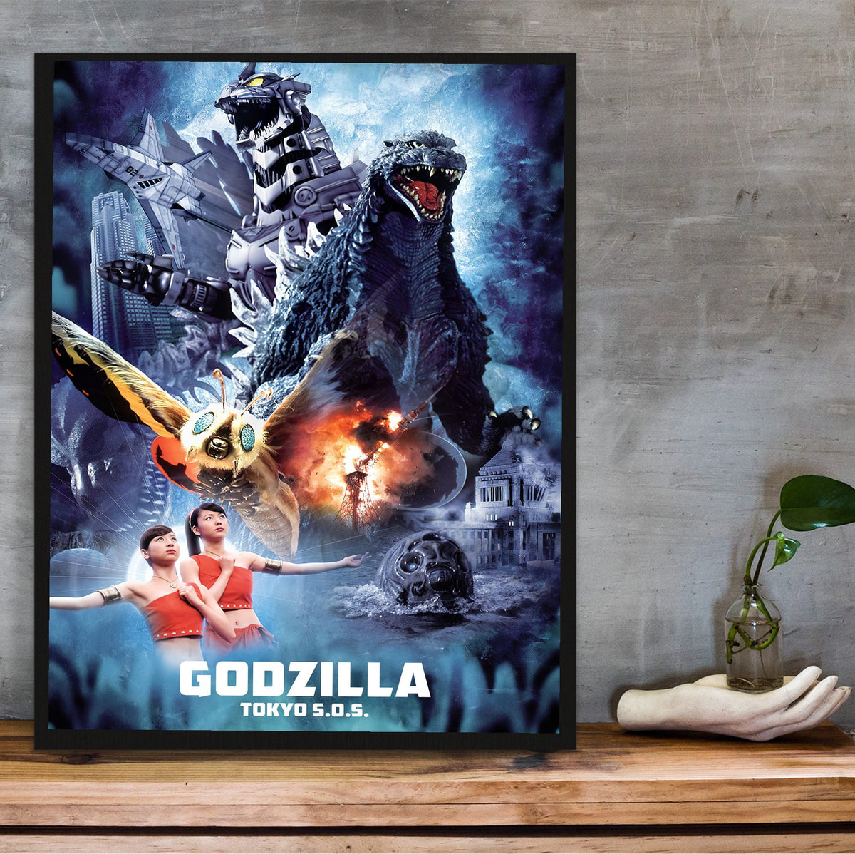 Godzilla: Tokyo S.O.S. (2003) Movie Key Art poster in a black frame on a wooden shelf against concrete