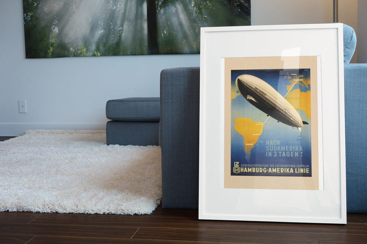 Graf Zeppelin to South America poster leaning beside a blue sofa