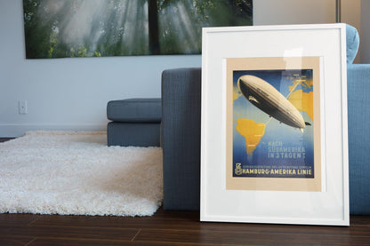 Graf Zeppelin to South America poster leaning beside a blue sofa