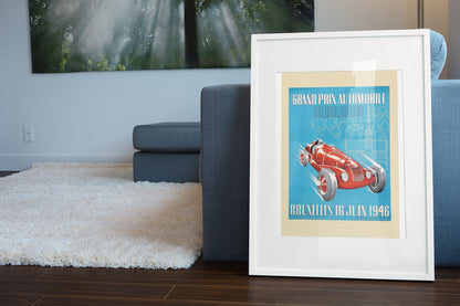 Grand Prix de Belgique Bruxelles 1946 poster in a white frame leaning beside a blue sofa