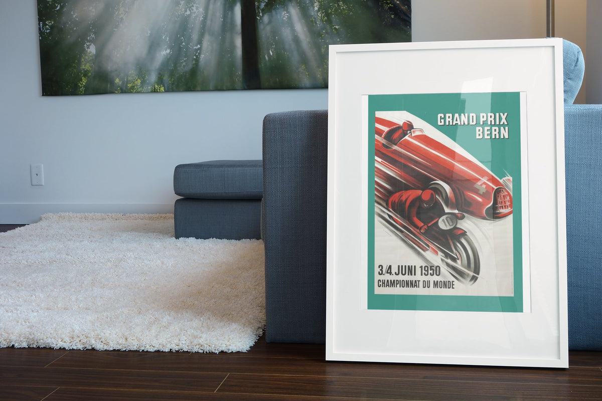 Grand Prix Bern 1950 poster in a white frame leaning beside a blue sofa