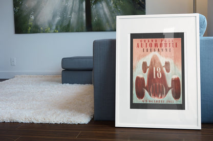 Grand Prix Lausanne 1947 poster in a white frame leaning beside a blue sofa