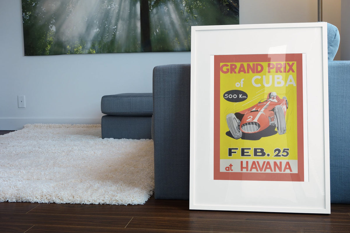 Grand Prix of Cuba Havana poster in a white frame leaning beside a blue sofa