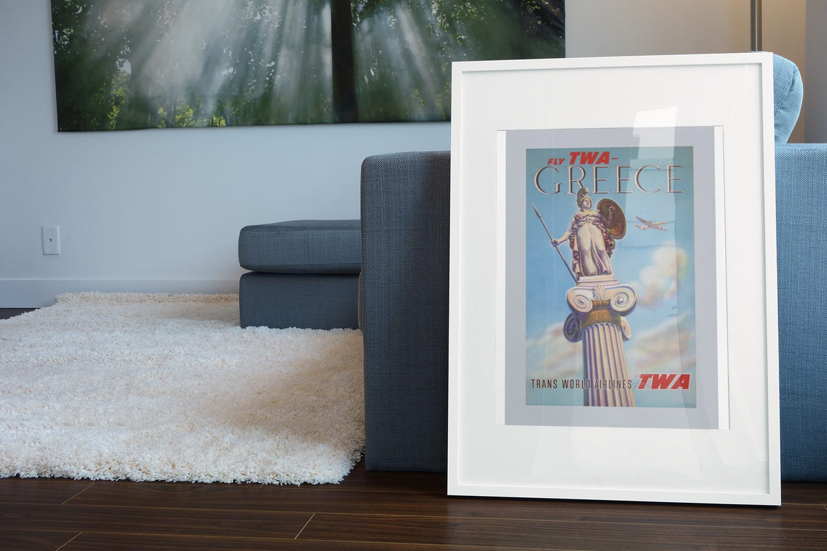 Greece Fly TWA 1955 poster leaning beside a blue sofa