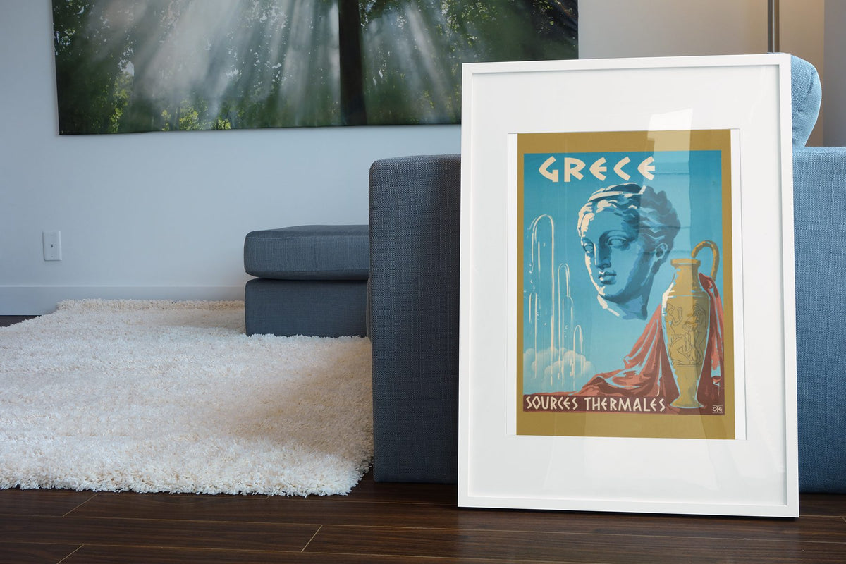 Greece Sources Thermales poster leaning beside a blue sofa