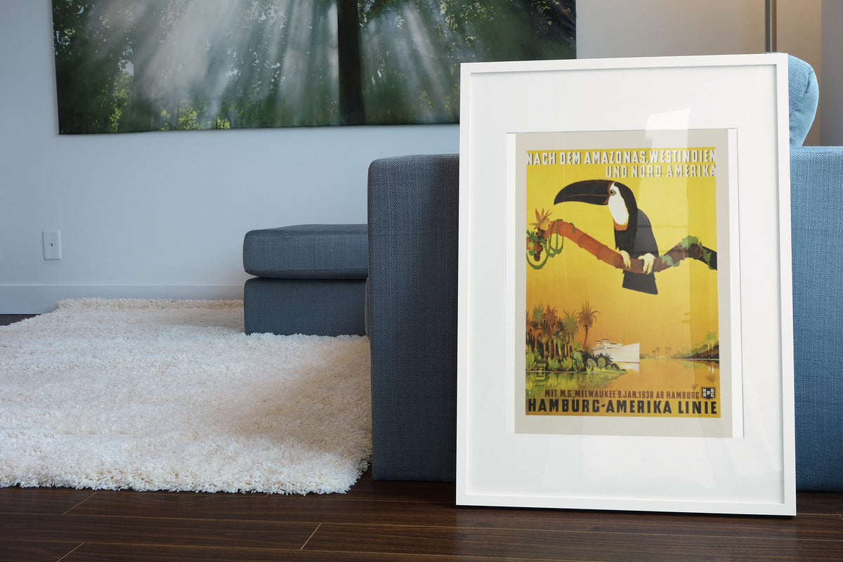 Hamburg Amerika Linie Amazon Toucan poster leaning beside a blue sofa