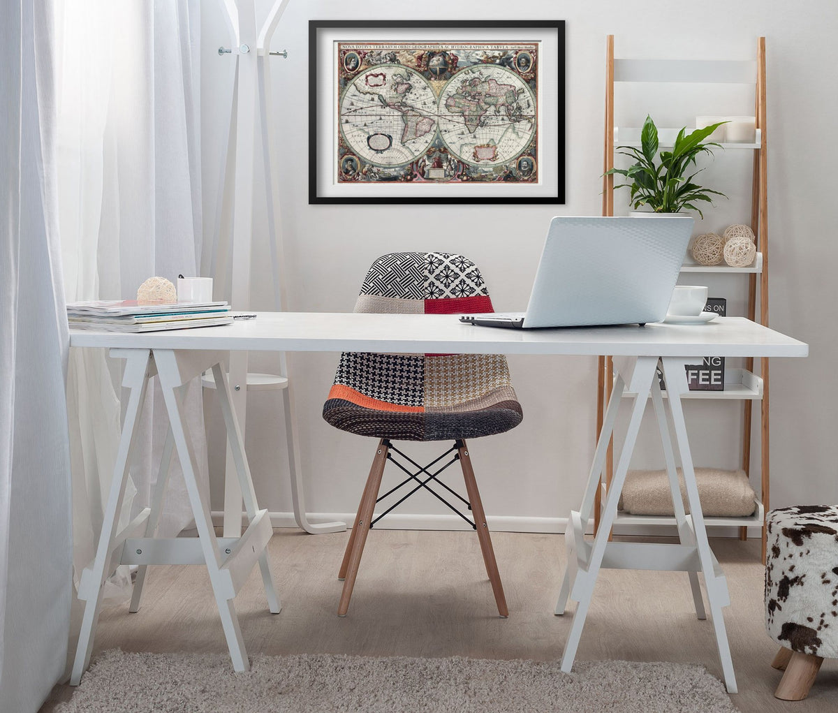 Hand-Coloured World Map 1630 framed above a white desk in a home office