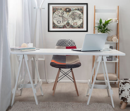 Hand-Coloured World Map 1630 framed above a white desk in a home office