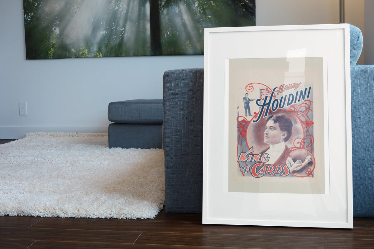 Harry Houdini King of Cards poster leaning beside a blue sofa
