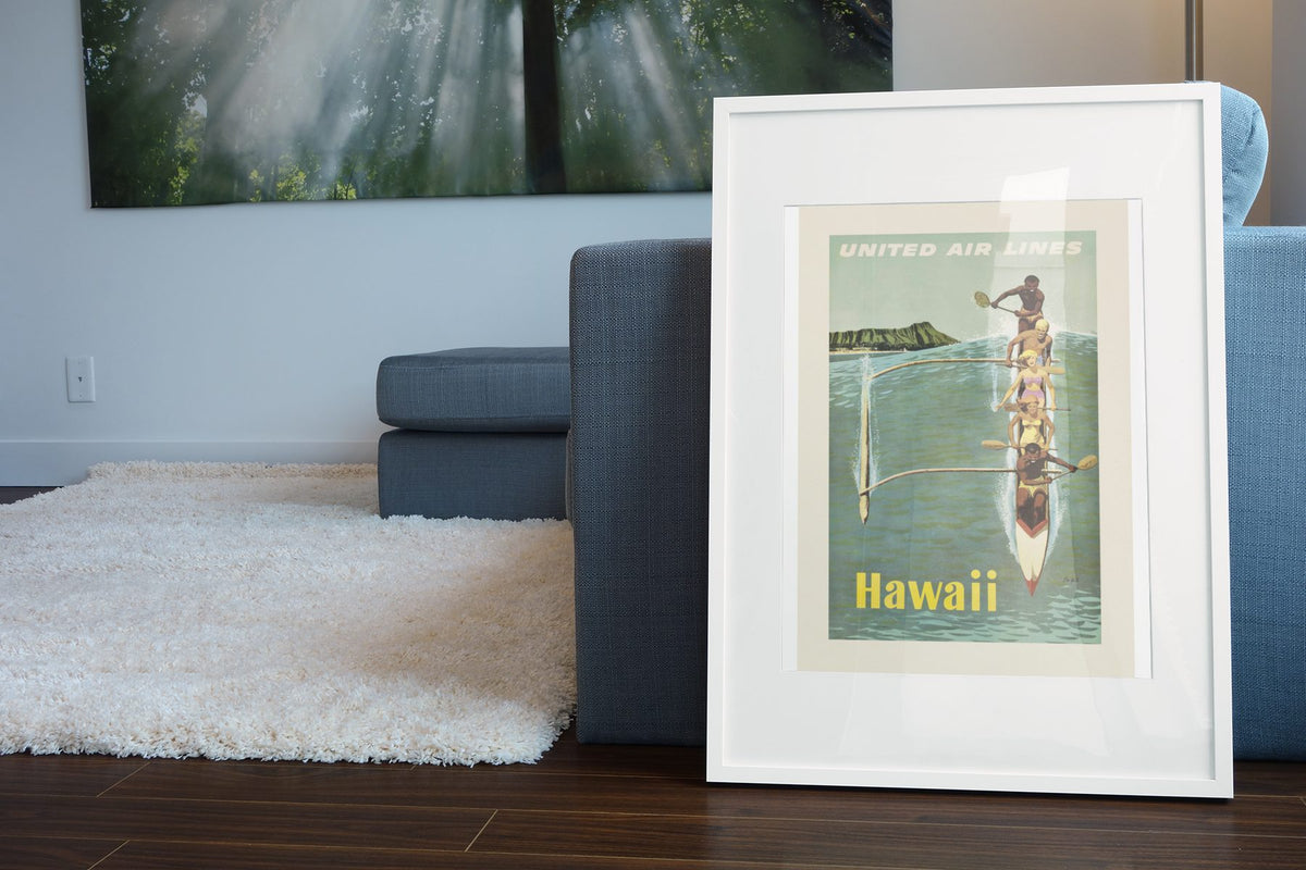 Hawaii Outrigger Canoe poster leaning beside a blue sofa