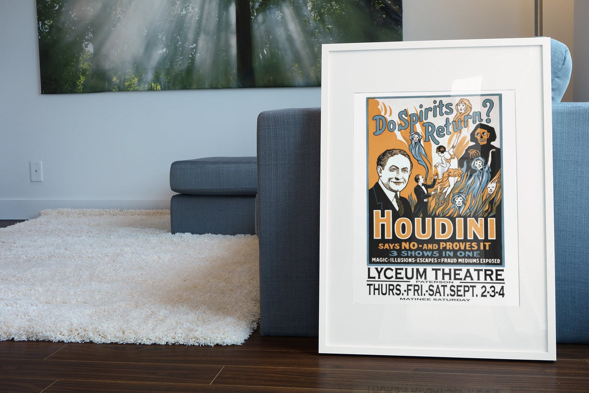 Houdini Do Spirits Return poster leaning beside a blue sofa
