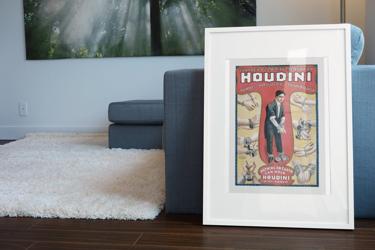 Houdini Handcuff King poster leaning beside a blue sofa