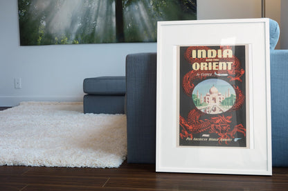 India and the Orient Pan Am poster leaning beside a blue sofa