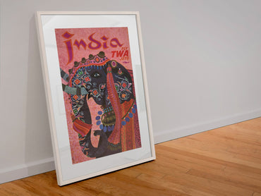 India Fly TWA poster in a white frame leaning against a wall