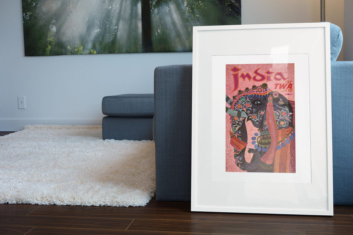 India Fly TWA poster leaning beside a blue sofa