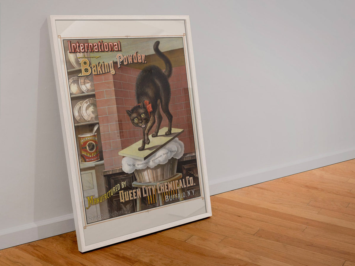 International Baking Powder Black Cat poster in a white frame leaning against a wall