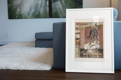 International Baking Powder Black Cat poster leaning beside a blue sofa