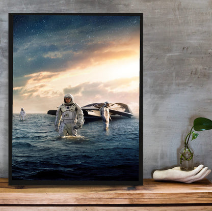 Interstellar (2014) Movie Water Planet Art poster in a black frame on a wooden shelf against concrete