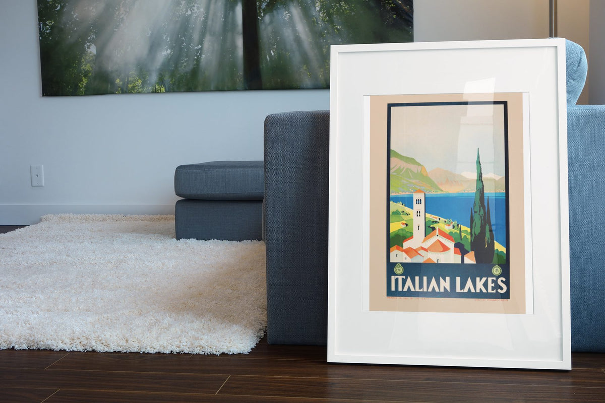 Italian Lakes poster leaning beside a blue sofa