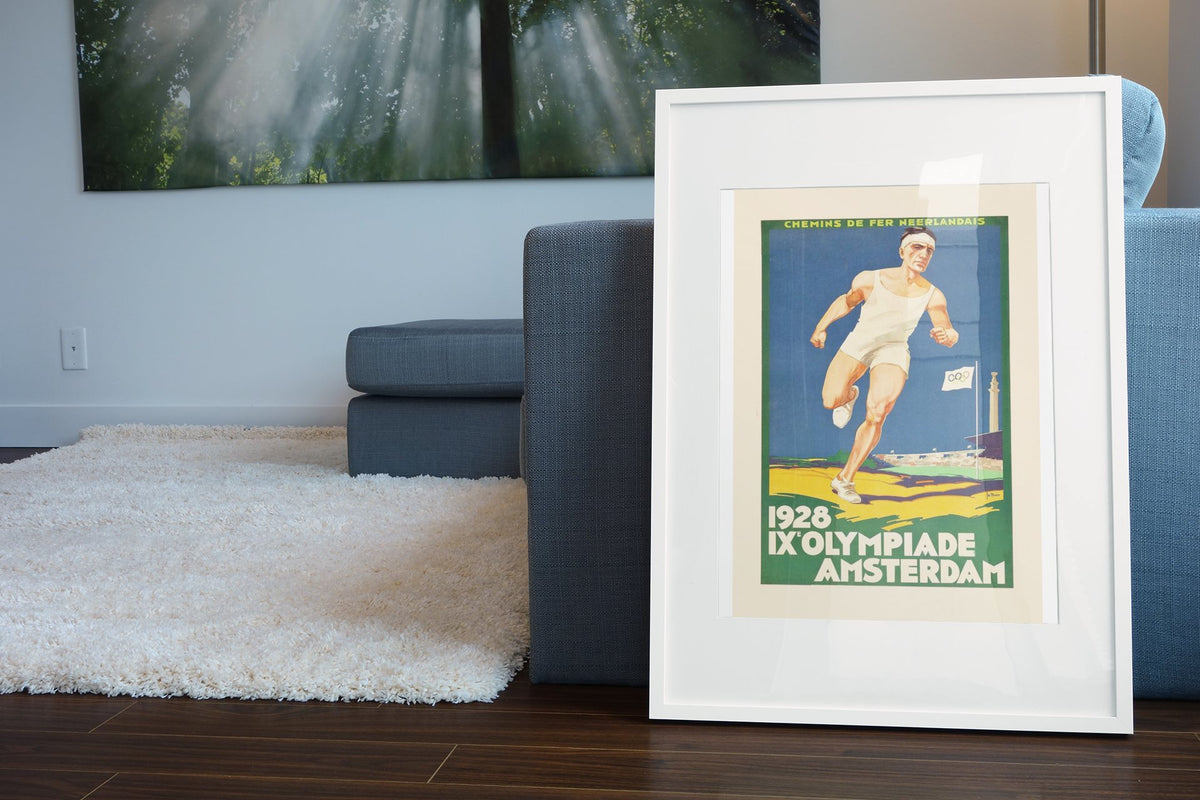 Amsterdam Olympics 1928 poster leaning beside a blue sofa