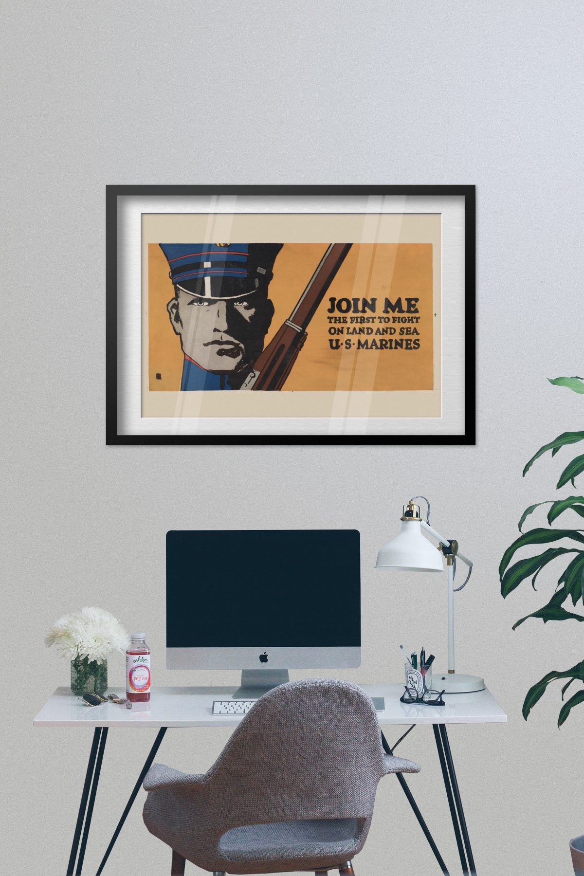 Join Me First to Fight US Marines poster framed on a grey wall above a desk
