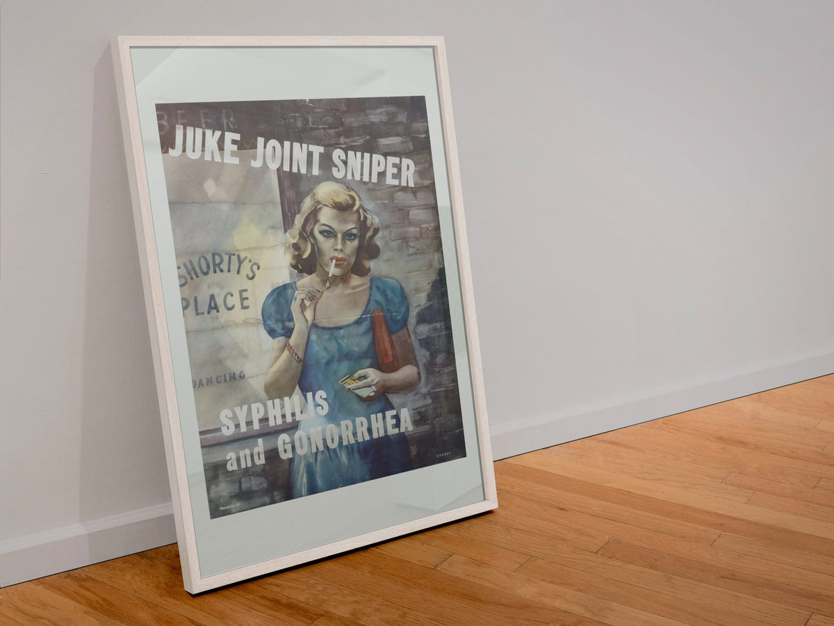 Juke Joint Sniper poster in a white frame leaning against a wall