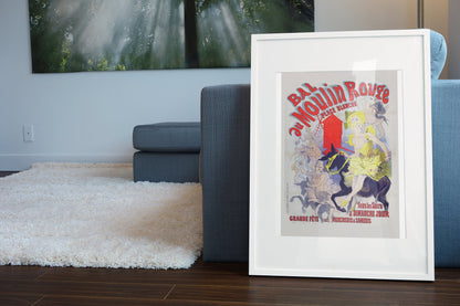 Jules Chéret Bal au Moulin Rouge poster in a white frame leaning beside a blue sofa