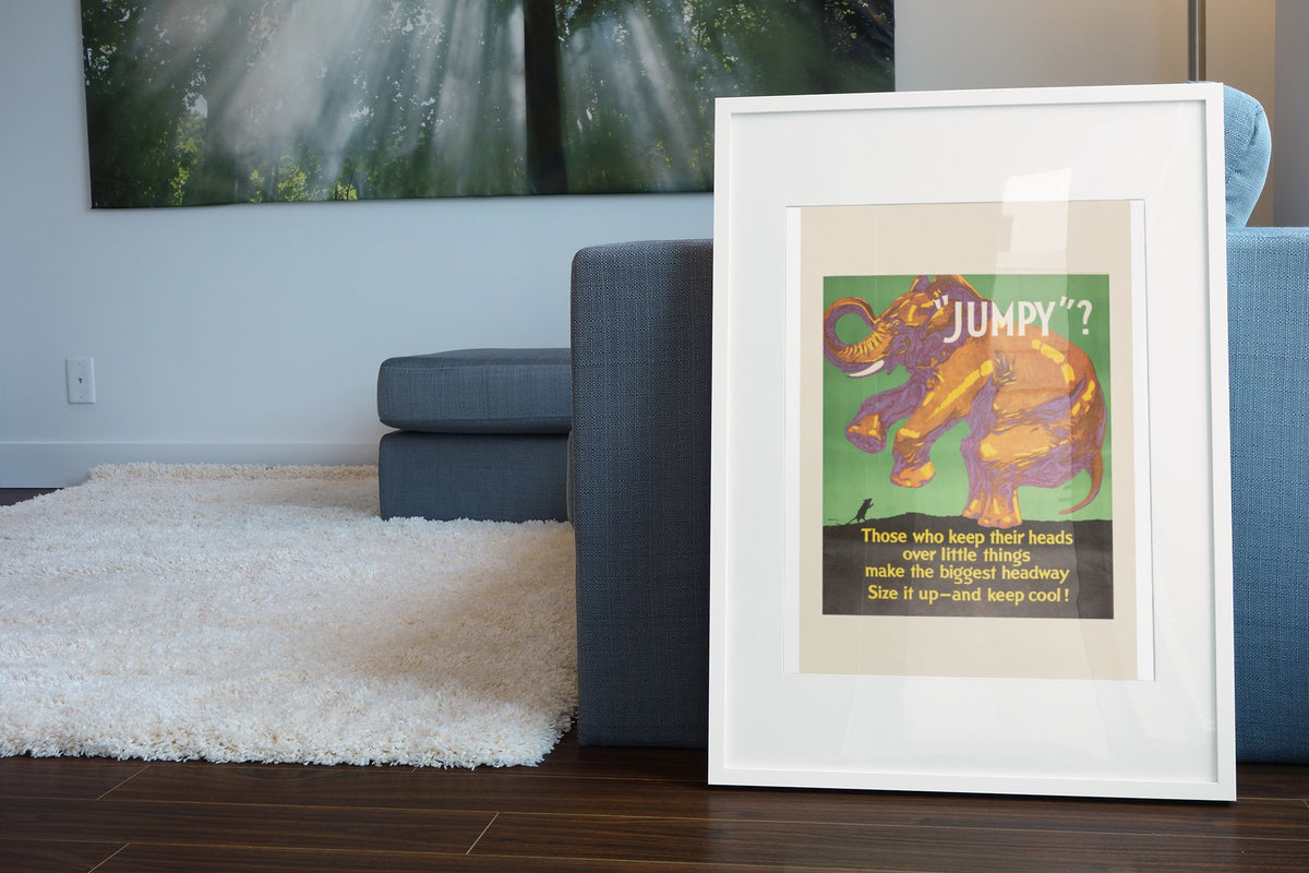 “Jumpy” poster in a white frame leaning beside a blue sofa