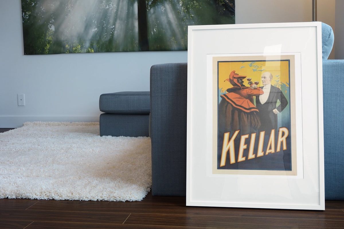 Kellar Drinks With the Devil poster leaning beside a blue sofa