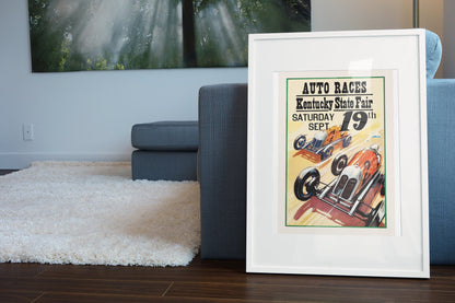 Kentucky State Fair Auto Races poster in a white frame leaning beside a blue sofa