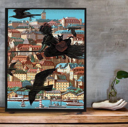 Kiki's Delivery Service Koriko Town Illustrated Art poster in a black frame on a wooden shelf against concrete