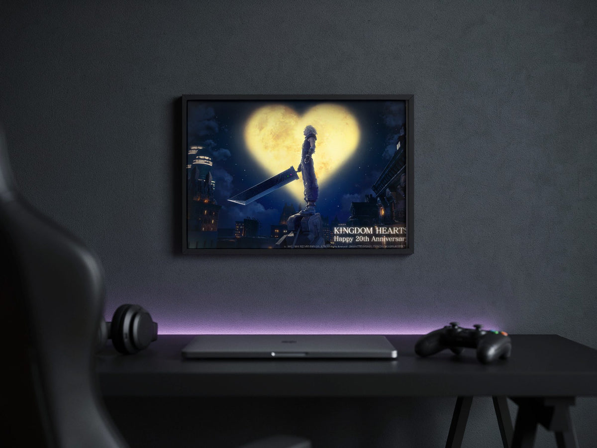 Kingdom Hearts 20th Anniversary Art poster in a black frame above a gaming desk