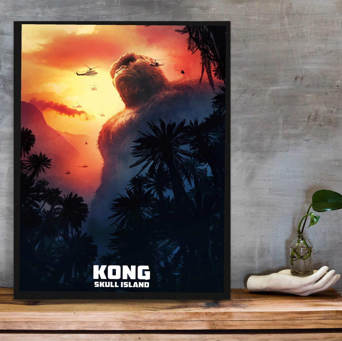Kong: Skull Island (2017) Movie Key Art poster in a black frame on a wooden shelf against concrete