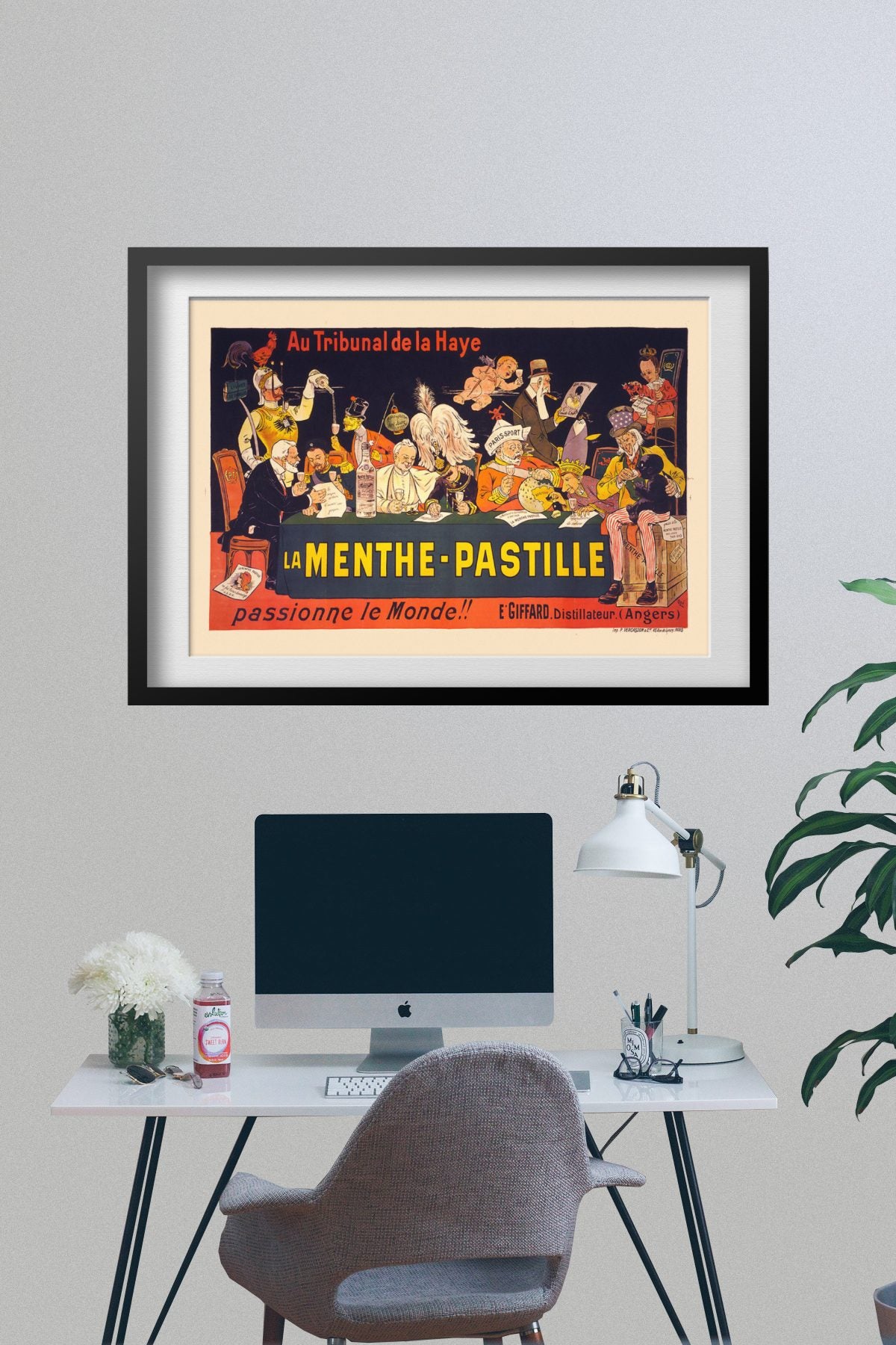 La Menthe-Pastille poster framed on a grey wall above a desk